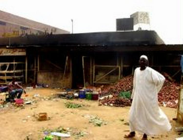 En arabisk mand står foran sit nedbrændte hus i Khartoum. Optøjer og kampe mellem tilhængere af afdøde Garang og præsidentens støtter har kostet mange døde og nedbrændte butikker. - Foto: AP 