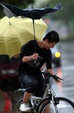 Den tropiske storm Matsa er på vej mod millionbyen Beijing. Fredag havde denne cyklist problemer, da stormen ramte Taiwan. - Foto: AP 