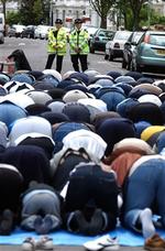 Britisk politi overvåger en bøn i det fri uden for Finsbury Park Moskeen i London. En yderligtgående prædikant siger, at han gerne vender hjem til Storbritannien   han er kun på ferie.   Foto: Adam Butler/AP 