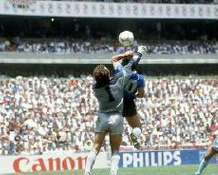 Diego Maradona får bokset bolden forbi den engelske målmand Peter Shilton og bringer Argentina foran i VM-kvartfinalen i 1986. Argentina vandt VM i 1986 via en 3-2-sejr over Vesttyskland. - Arkivfoto: Polfoto. 