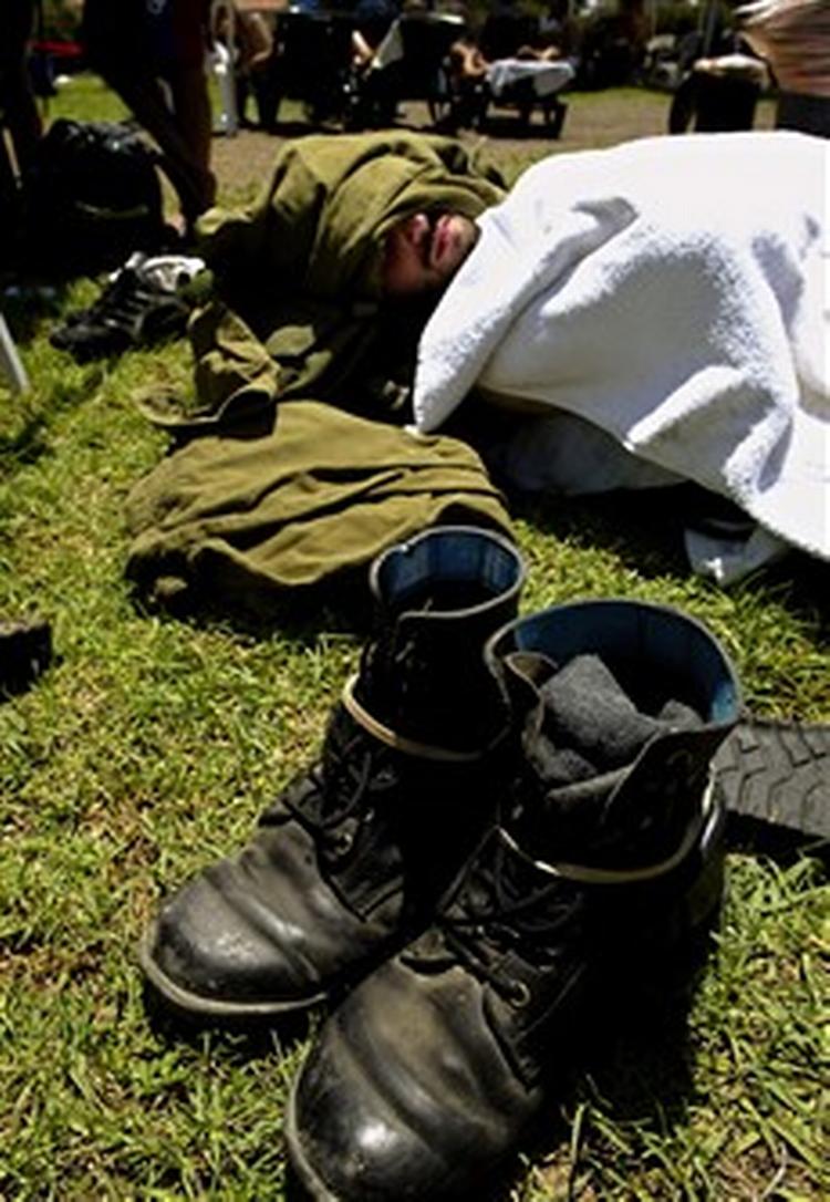 En israelsk soldat tager sig et hvil i landsbyen Bat-Hadar, kort før soldaterne skal starte en øvelse i at evakuere jødiske bosættelser i Gaza.   Foto: AP 