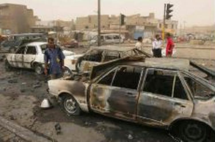Lokale irakere inspicerer et bombetomt i går i Bagdad. - Foto: AP 