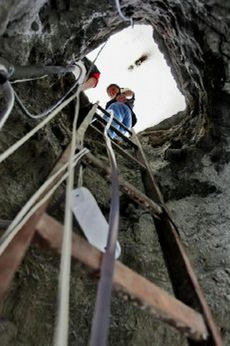 En politimand kigger ned i den tunnel, som tyve gravede over tre måneder for at røve den brasilianske nationalbank. - Foto: AP 