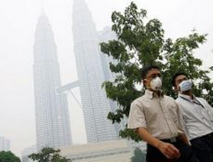 Muslimer i Malaysia på vej til fredagsbøn i tyk røg i Kuala Lumpur. - Foto: AP 