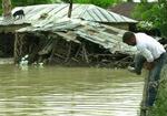 En mand forcerer et hegn i byen Ivesti, 330 km. nord for Bukarest, hvor oversvømmelserne har hærget det meste af sommeren. - Foto: AP 