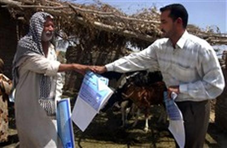 En irakisk embedsmand er ude med plakater, der skal oplyse irakerne om folkeafstemningen 15. oktober, hvor irakerne skal sige ja eller nej til forslaget til ny forfatning for Irak.   Foto: Alaa al-Marjani/AP 