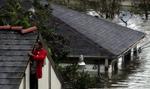 En mand holder godt fast i sit hus i New Orleans. Byen slap forholdsvis nådigt - tre personer omkom under Katrinas hærgen. - Foto: AP 