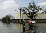 Borgere i New Orleans vandrer gennem vand, der fortsatte med at stige i byens gader. - Foto: AP 