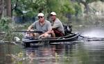 New Orleans hærges af plyndringer. På billedet er to beboere på vej mod faderens hus for at redde deres værdifulde ting - Foto: AP 