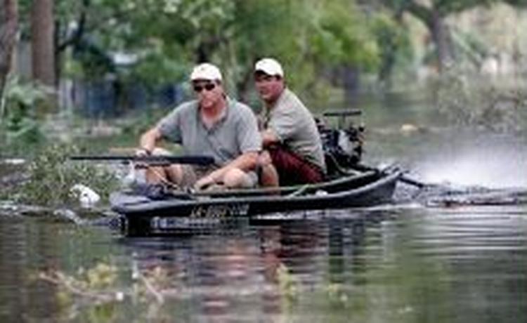 New Orleans hærges af plyndringer. På billedet er to beboere på vej mod faderens hus for at redde deres værdifulde ting - Foto: AP 