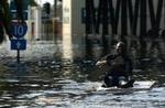En mand padler gennem vandmasserne hen mod Superdome i New Orleans. Katastrofen vil kræve den største redningsaktion i USA's historie - Foto: AP 