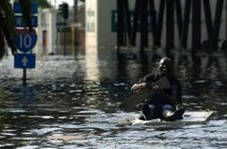 En mand padler gennem vandmasserne hen mod Superdome i New Orleans. Katastrofen vil kræve den største redningsaktion i USA's historie - Foto: AP 