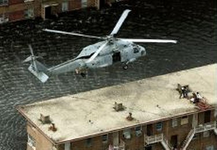 En redningshelikopter gør klar til at løfte strandede mennesker fra tagene i New Orleans. Redningsarbejdet er udsat for hård kritik. - Foto: AP 