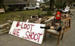 'Du plyndrer, vi skyder', hedder det på dette skilt. Nu får borgerne hjælp fra kampklare soldater til at bekæmpe de kriminelle bander i New Orleans. - Foto: AP 