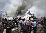 Redningsfolk forsøger at redde overlevende fra flystyrtet på Sumatra. 16 overlevede flystyrtet i et beboelseskvarter. - Foto: AP 