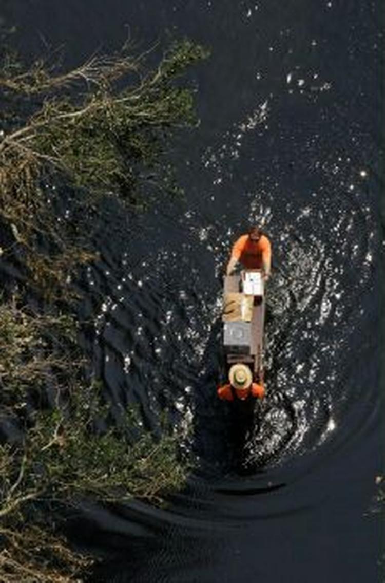 To mænd skubber deres ejendele gennem vandet i New Orleans. - Foto: AP 