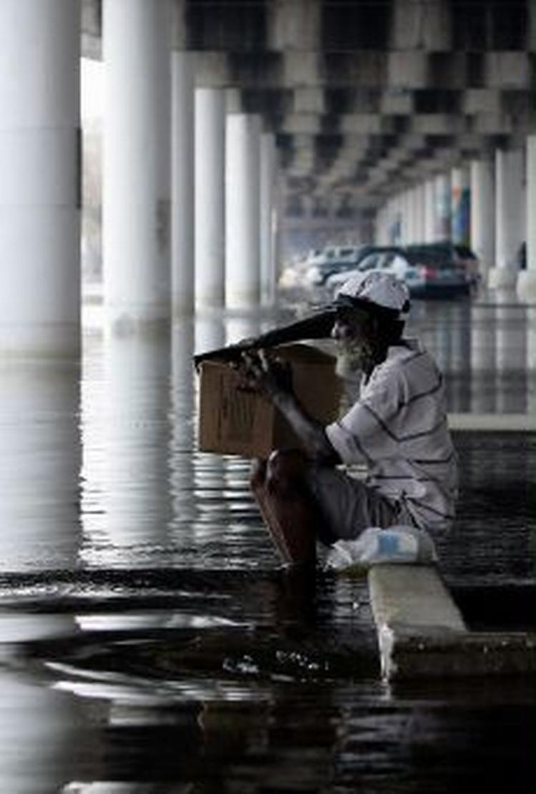En mand sidder under en motorvejsbro i New Orleans, hvor vandstanden stadig er høj. Mange er evakuerede, men enkelte ønsker at blive tilbage - selv om det er farligt. - Foto: AP 
