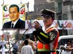 Trafikbetjent foran en valgplakat for den siddende præsident Mubarak. Egypterne kan denne gang vælge mellem ti kandidater, men det bliver Mubarak, der vinder. - Foto: AP 