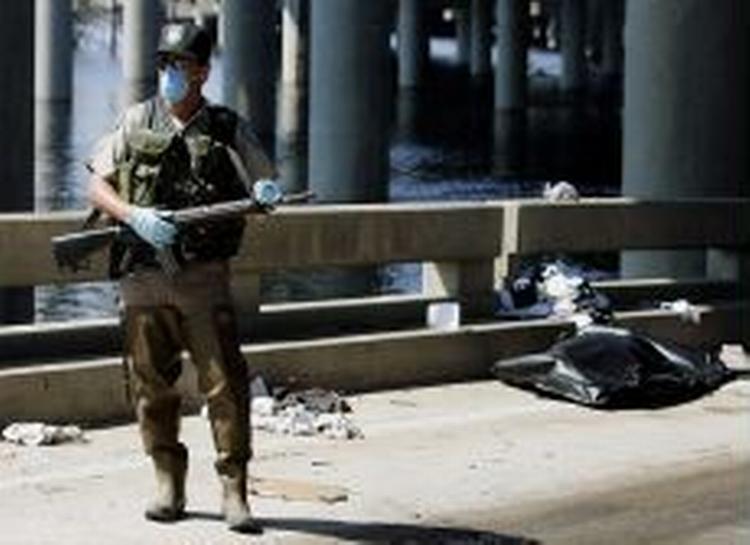 Stanken i New Orleans er så slem, at de udsendte soldater må gå med ansigtsmaske. - Foto: AP 