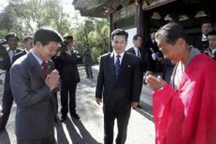Sydkorea genforeningsminister Chung Dong-young (tv) hilser på en nordkoreansk munk og hans modpart fra Nordkorea Kwon Ho Ung (midt) før forhandlinger mellem de to lande i dag. - Foto: AP 