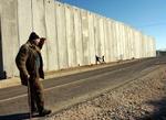 En palæstinenser ser på legende børn ved Israels sikkerhedsmur på Vestbredden. Israels Højesteret har bestemt at muren ikke må følge den oprindelige linjelægning. - Arkivfoto: AP 