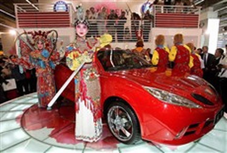 Bilerne fra Kina - her en Geely - blev præsenteret på biludstillingen i Frankfurt med flotte farver og sang og dans. Men det kan ikke dække over, at bilerne endnu er langt fra europæisk standard. Foto: AP 