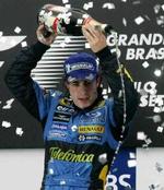 En glad Fernando Alonso sprøjter champagne. - Foto: AP 