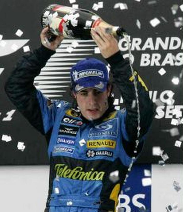 En glad Fernando Alonso sprøjter champagne. - Foto: AP 
