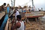 Arbejdere reparerer en ødelagt båd i Nagappattinam, den indiske region, som blev hårdest ramt af tsunamien. Sådanne naturkatastrofer driver millioner på flugt. - Foto: AP 