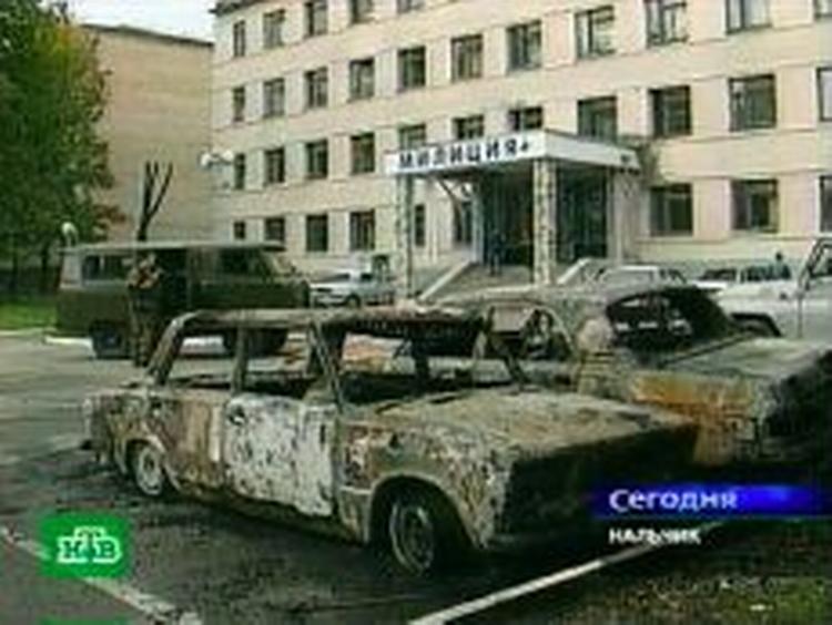 Oplysninger fra Naltjik er modstridende. De russiske myndigheder siger ét og øjenvidner i byen noget andet. Her udbrændte biler foran en politistation i Naltjik. - Foto: AP 
