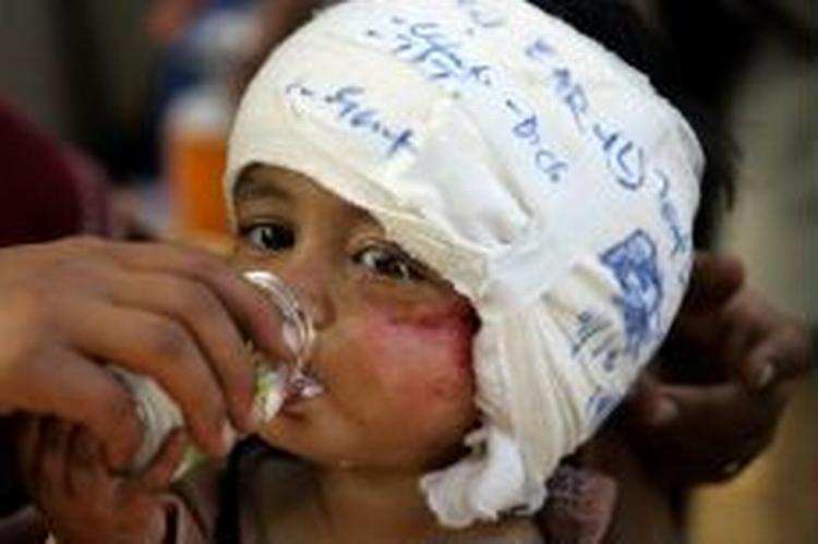 En kvinde giver sit barn vand efter behandling for skader efter jordskælvet i Kashmir på en klinik i Muzaffarabad. Kvinder står for langt hovedparten af dødsfald efter jordskælvet. - Foto: AP 