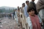 Pakistanske overlevende fra jordskælvet i Kashmir venter i kø på at få nødhjælp. Katastrofen har fået de gamle fjender Pakistan og Indien til at åbne grænserne i Kashmir. - Foto: AP 