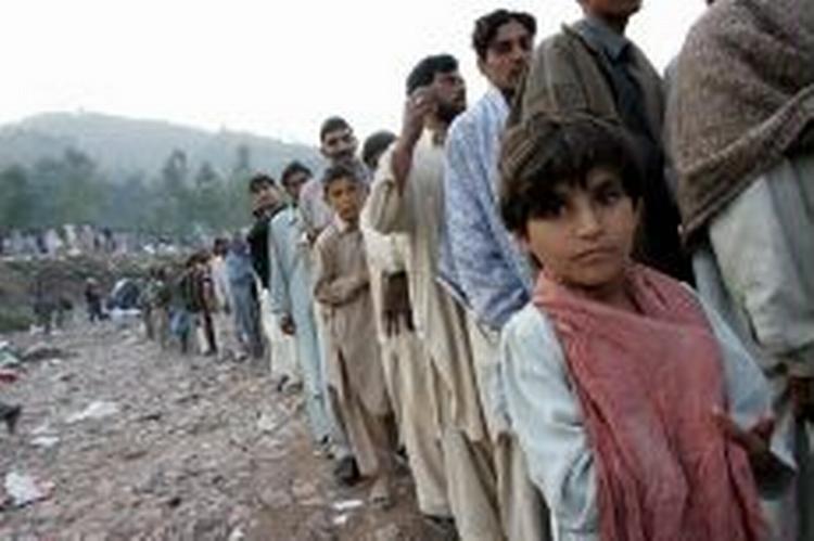 Pakistanske overlevende fra jordskælvet i Kashmir venter i kø på at få nødhjælp. Katastrofen har fået de gamle fjender Pakistan og Indien til at åbne grænserne i Kashmir. - Foto: AP 