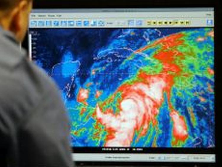 Meteorologen Daniel Brown studerer et infrarødt billede af Wilma. - Foto: AP 