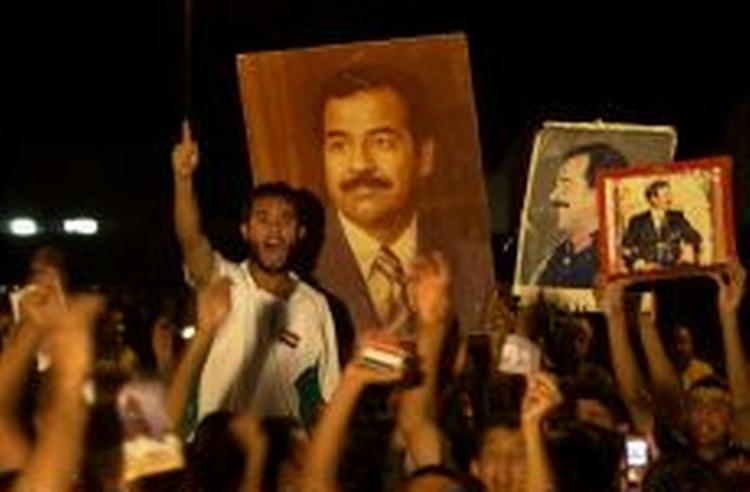 Irakere forsvarer Saddam Hussein ved en demonstration i hans hjemby Tikrit i går aftes. - Foto: AP 