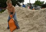 Syvårige Benjamin hjælper sin far med at fylde sandsække i Bonita Springs, Florida. - Foto: AP 