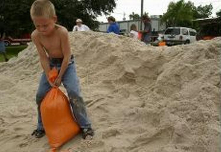 Syvårige Benjamin hjælper sin far med at fylde sandsække i Bonita Springs, Florida. - Foto: AP 