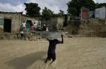 En dreng fra et slumkvarter i Haiti bærer et stykke tag fra et hus, der blev ødelagt af den tropiske storm Alpha. - Foto: AP 
