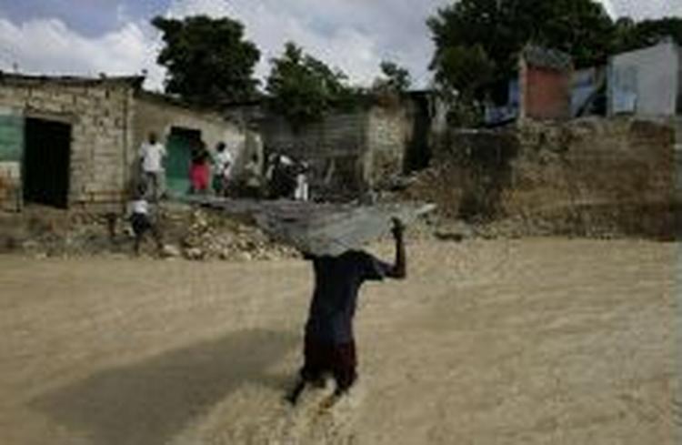 En dreng fra et slumkvarter i Haiti bærer et stykke tag fra et hus, der blev ødelagt af den tropiske storm Alpha. - Foto: AP 