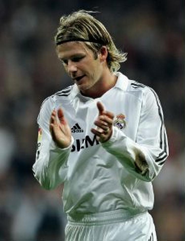 Real Madrids engelske stjernespiller David Beckham klapper sarkastisk af dommerens gule kort til ham i kampen mod Sevilla. Det gav et gult kort mere, men det kort er nu ophævet af disciplinærkomiteen, så Beckham undgår karantæne. - Foto: AP 