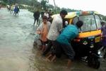 En rickshaw er strandet i vandmasserne, før den tropiske storm, der ventes i løbet af dagen. - Foto: AP 