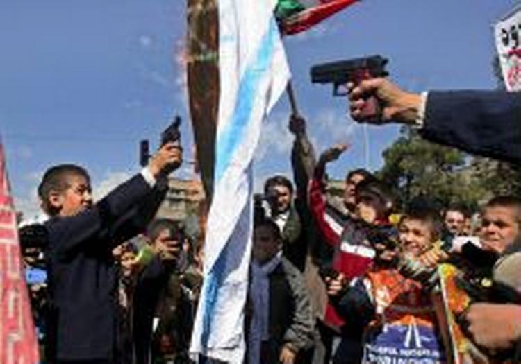 Iranske skolebørn 'beskyder' det israelske flag med legetøjpistoler under en antiisraelsk demonstration i Teheran. - Foto: APA! 