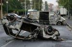 Mindst 19 biler blev sat i brand under urolighederne fredag aften. - Foto: AP 