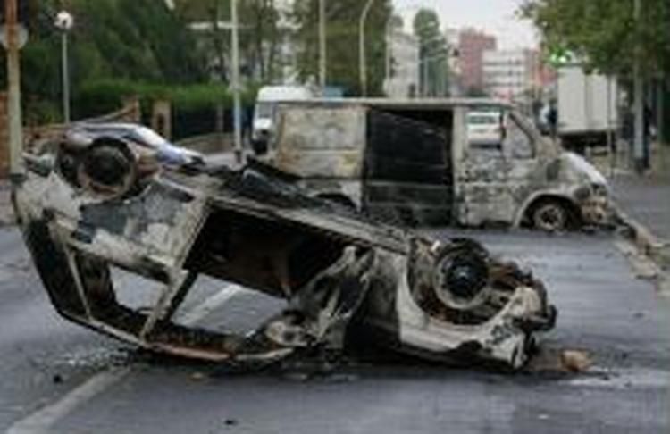 Mindst 19 biler blev sat i brand under urolighederne fredag aften. - Foto: AP 
