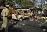 En politimand tilser ødelæggelserne efter en af eksplosionerne i New Delhi. - Foto: AP 