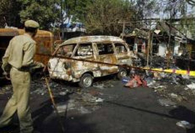 En politimand tilser ødelæggelserne efter en af eksplosionerne i New Delhi. - Foto: AP 
