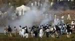 Pakistansk politi affyrede tåregas mod landsbyboere, der ville krydse grænsen, da der for første gang blev åbnet for nødhjælp mellem Indien og Pakistan i Kashmir. - Foto: AP 