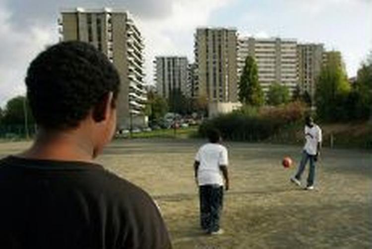 Unge spiller bold i Grigny, en af de Paris-forstæder, der har været hjemsøgt af uro de seneste uger. - Foto: AP 