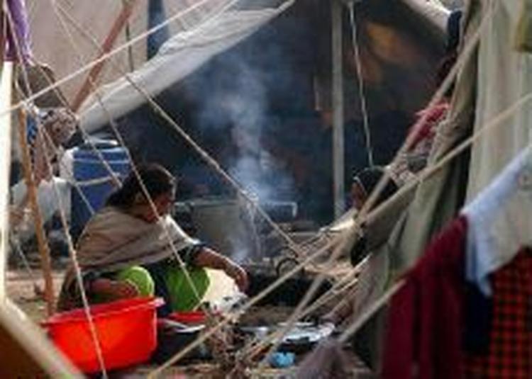 Kvinder i en teltlejr i Kashmirs hovedby Muzaffarabad vasker op. En udsendt læge fra Dansk Røde Kors forudser, at folk over vinteren kommer til at dø af helt banale sygdomme i Kashmirs kulde. - Foto: AP 