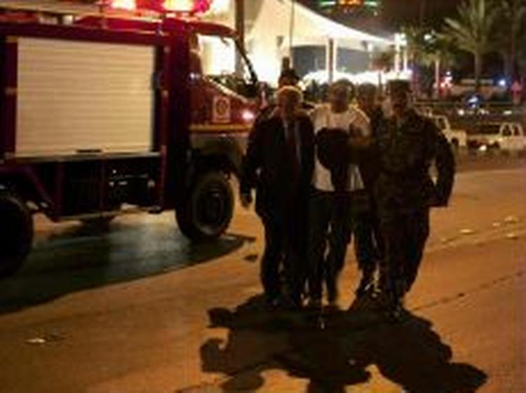 Politifolk hjælper en tilskadekommen uden for et af de tre bomberamte hoteller i Amman, Jordan. En dansk ambassadør var på SAS-hotellet, da det blev ramt af bomben. - Foto: AP 